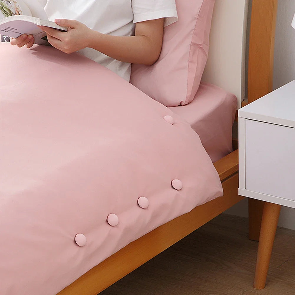 Stay-Put Duvet Clips holding a pink duvet cover smooth along the edge of a made bed