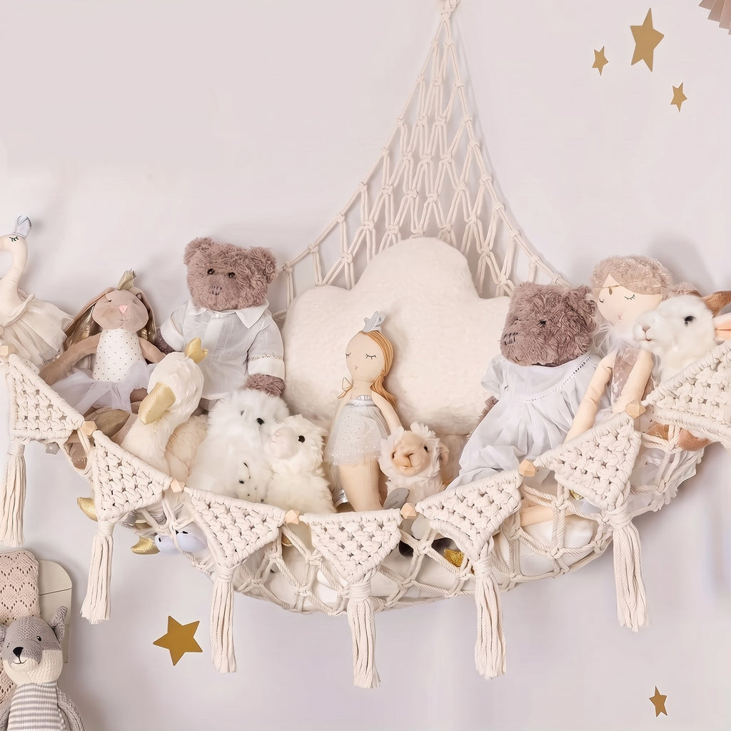 Beige Macrame Stuffed Animal Hammock hung across a corner, filled with teddy bears and dolls