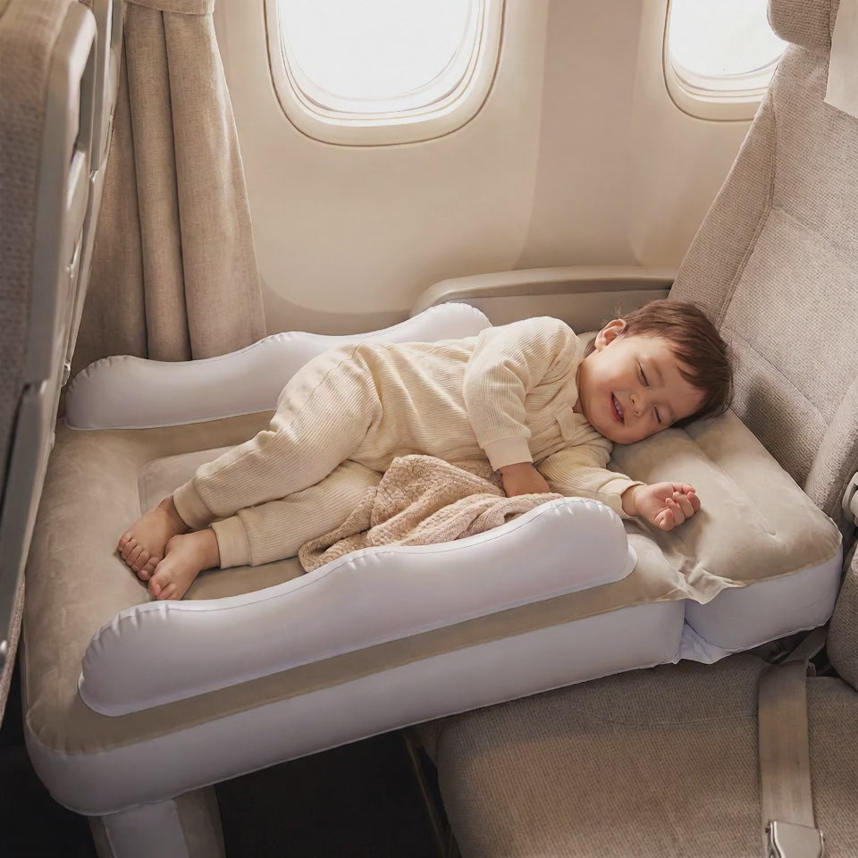 Toddler sleeping flat on the inflatable travel bed on an airplane