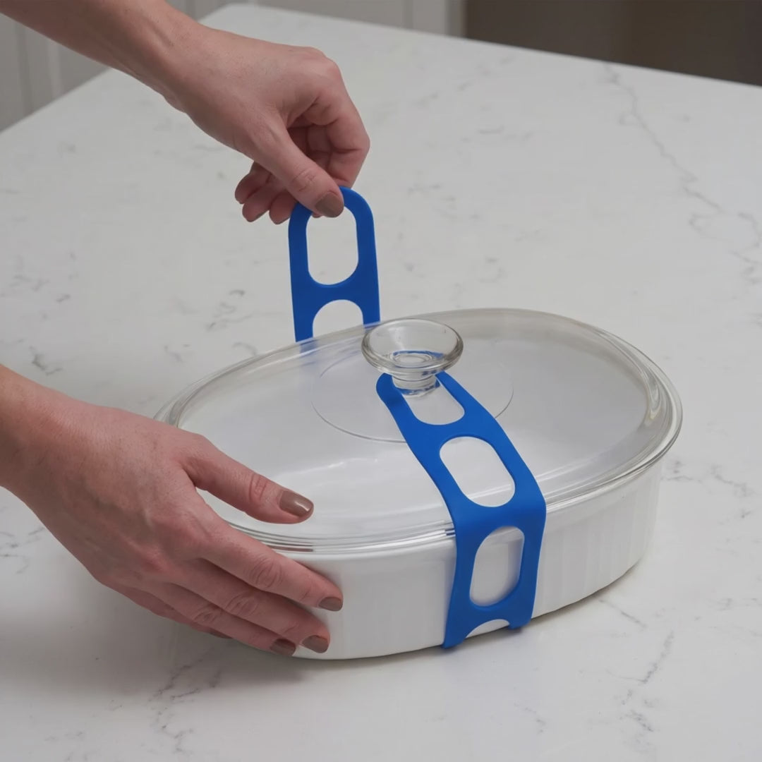 Stretch Lid Strap: hands hook the blue strap around a casserole dish, the grey strap holds a slow cooker lid as it is lifted, a Dutch oven carried by its side handles