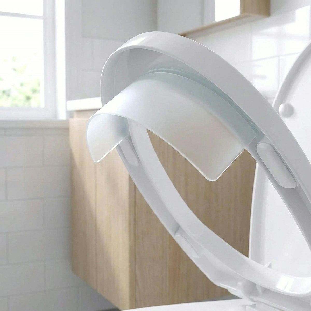 Close up of the splash guard adhered under the front of a raised toilet seat