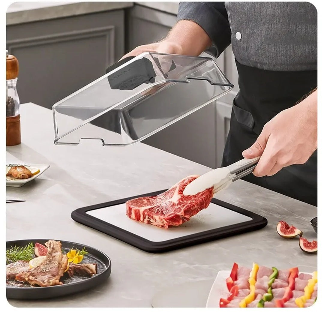 Lifting the clear lid off the Quick Thaw Defrosting Box to set a steak on the tray with tongs
