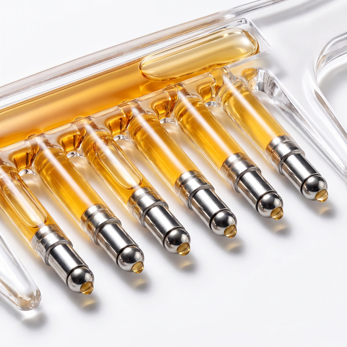 Close-up of the Scalp Serum Applicator Comb's seven roller-ball teeth with serum inside each one