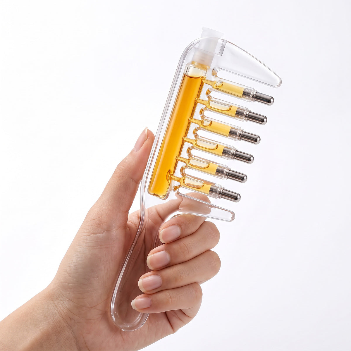 Scalp Serum Applicator Comb held in a hand for scale, white silicone cap at the top