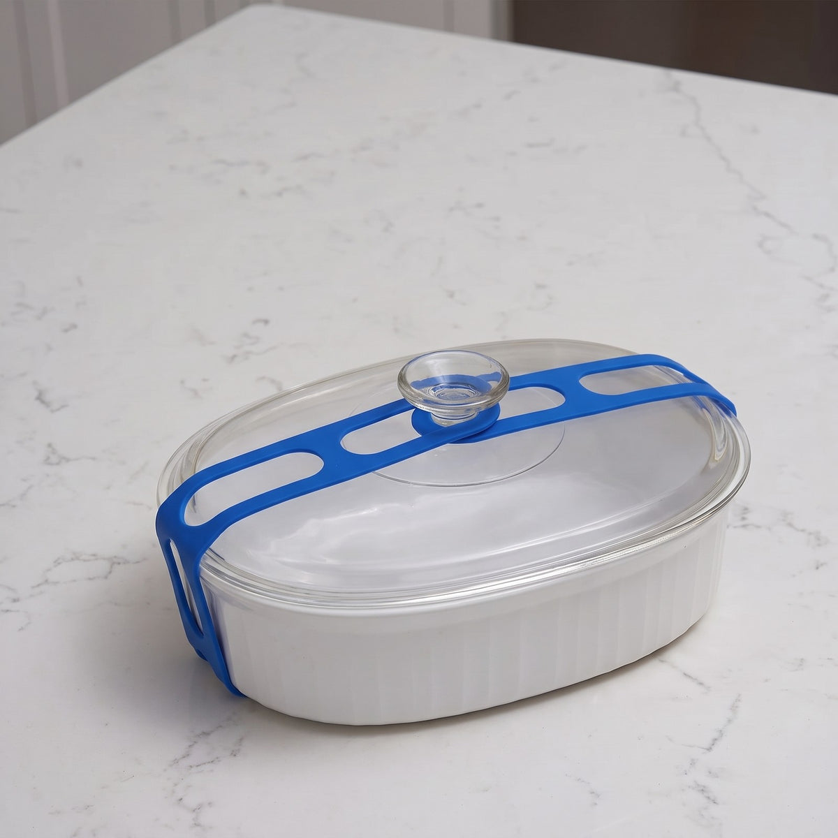 Stretch Lid Strap in blue wrapped around a white casserole dish and hooked over the glass lid knob