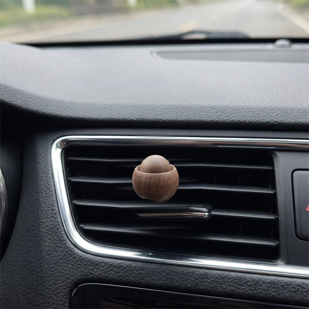 The wooden diffuser clipped onto a car air vent slat, about the size of a walnut