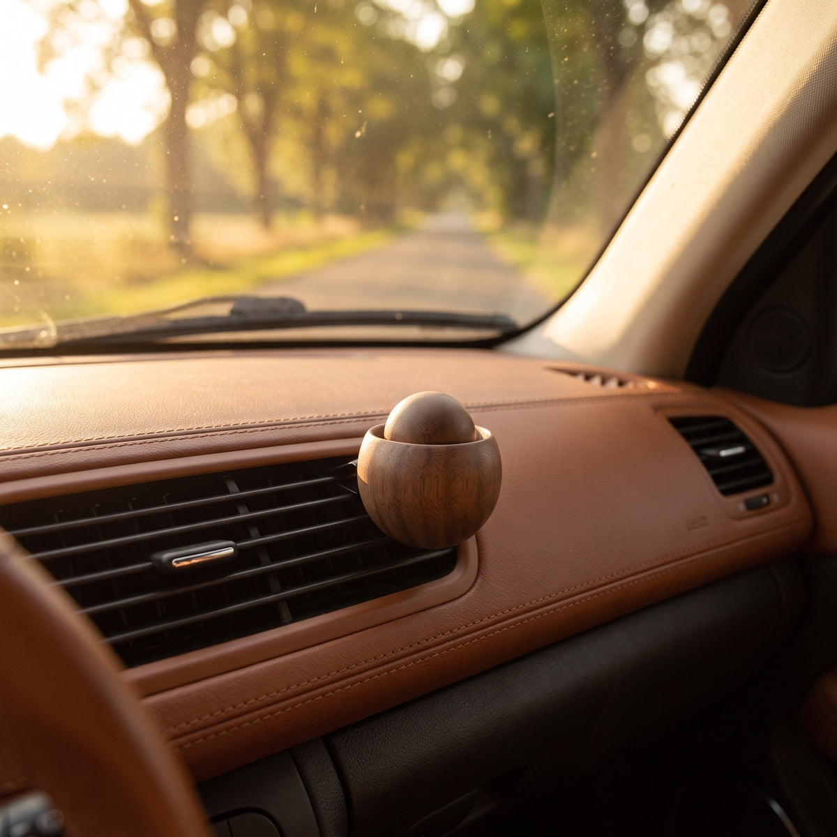 A sunlit car interior with the wooden diffuser clipped to the vent