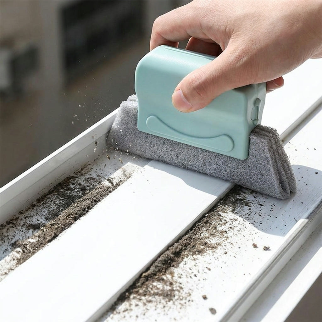 Hand pulling the groove brush along a dirty window track collecting debris in one line